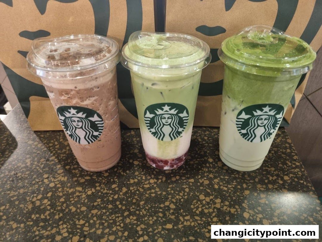 Three Starbucks drinks with the iconic logo displayed on each cup.