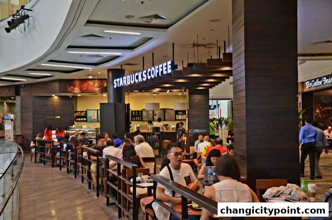 Interior view of a busy Starbucks coffee shop with customers seated and ordering.