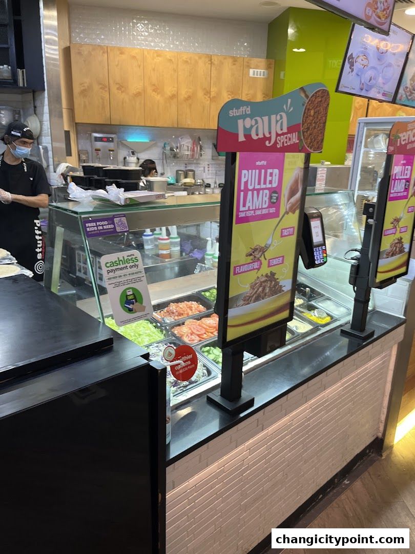 A food counter at Stuff'd with fresh ingredients and a special Pulled Lamb promotion.