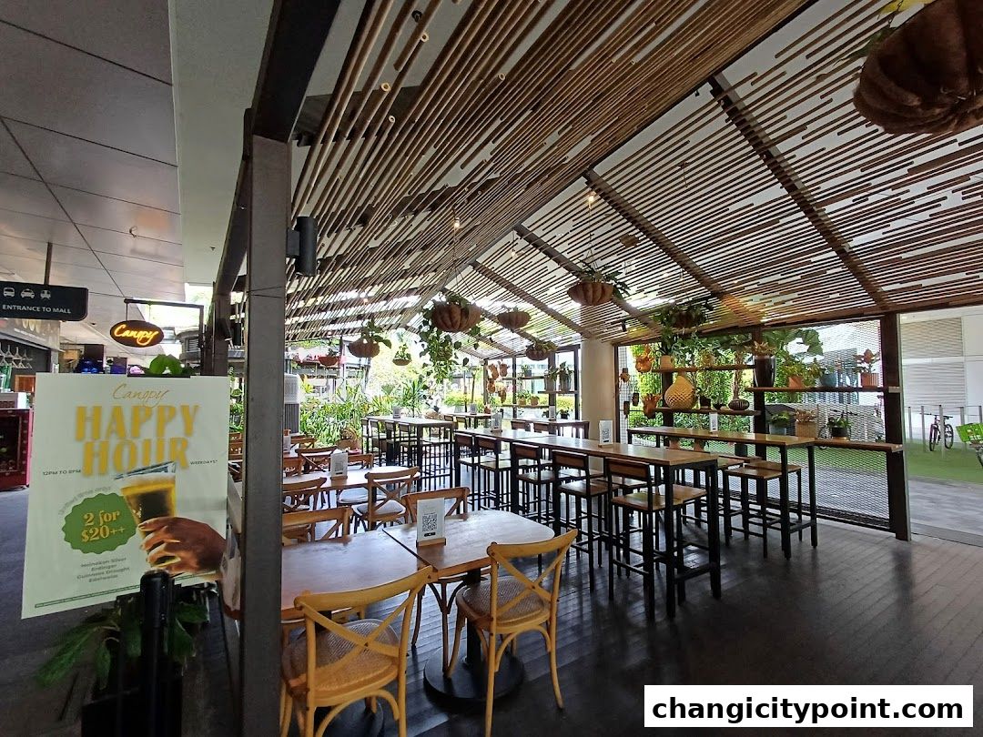 Interior of a restaurant with wooden tables, chairs, and hanging plants.