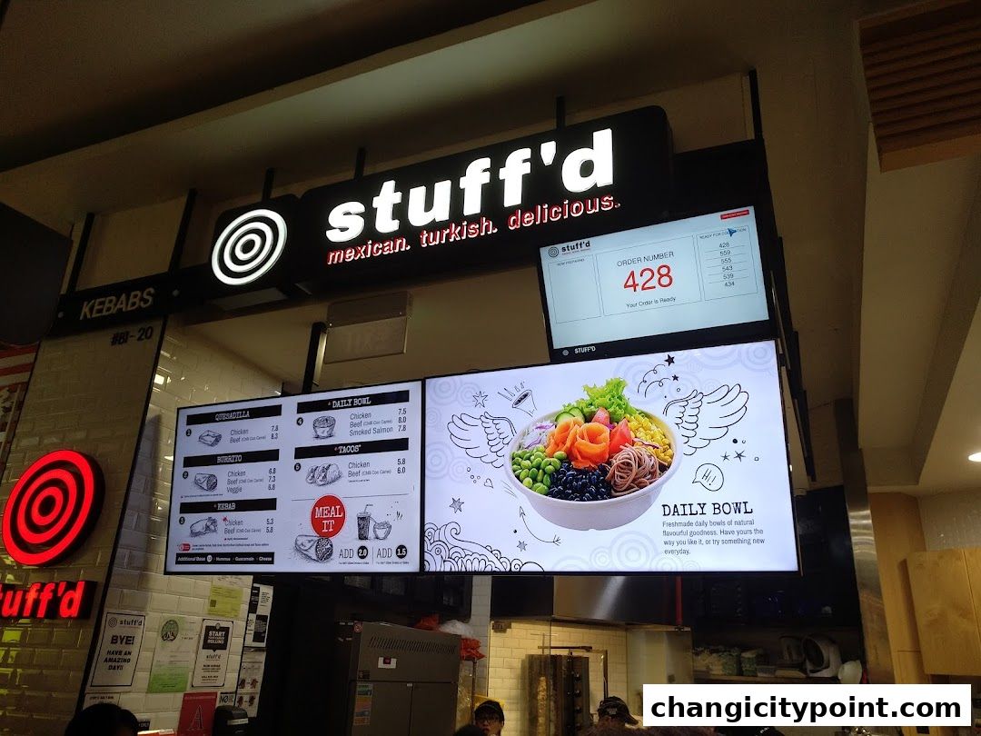 A food stall named 'Stuff'd' with a digital menu displaying bowls, burritos, tacos, and kebabs.