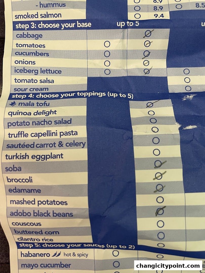 A close-up of a menu from Stuffd, detailing choices for bases, toppings, and sauces.