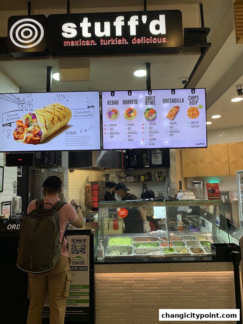 A digital menu board displays Kebab, Burrito, Daily Bowl, Quesadilla, and Chips & Dip options at Stuff'd.