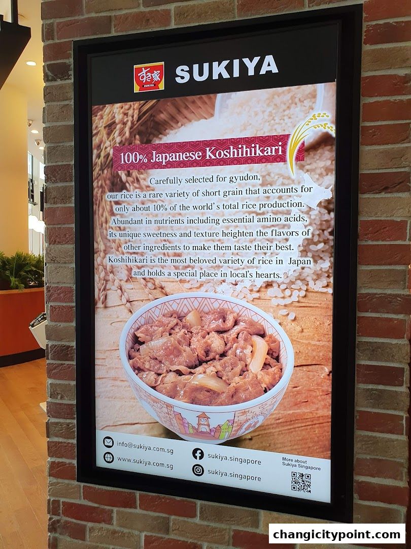 A Sukiya advertisement showcasing 100% Japanese Koshihikari rice and a bowl of gyudon.