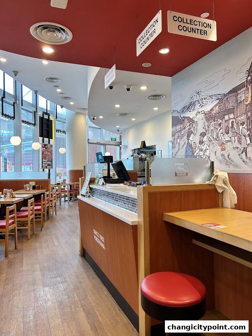 Interior view of Sukiya Gyudon & Curry restaurant with seating and counter.