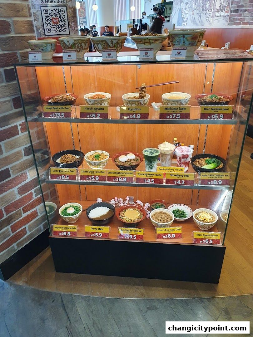 A display case showcasing various Japanese rice bowls and drinks with their prices.