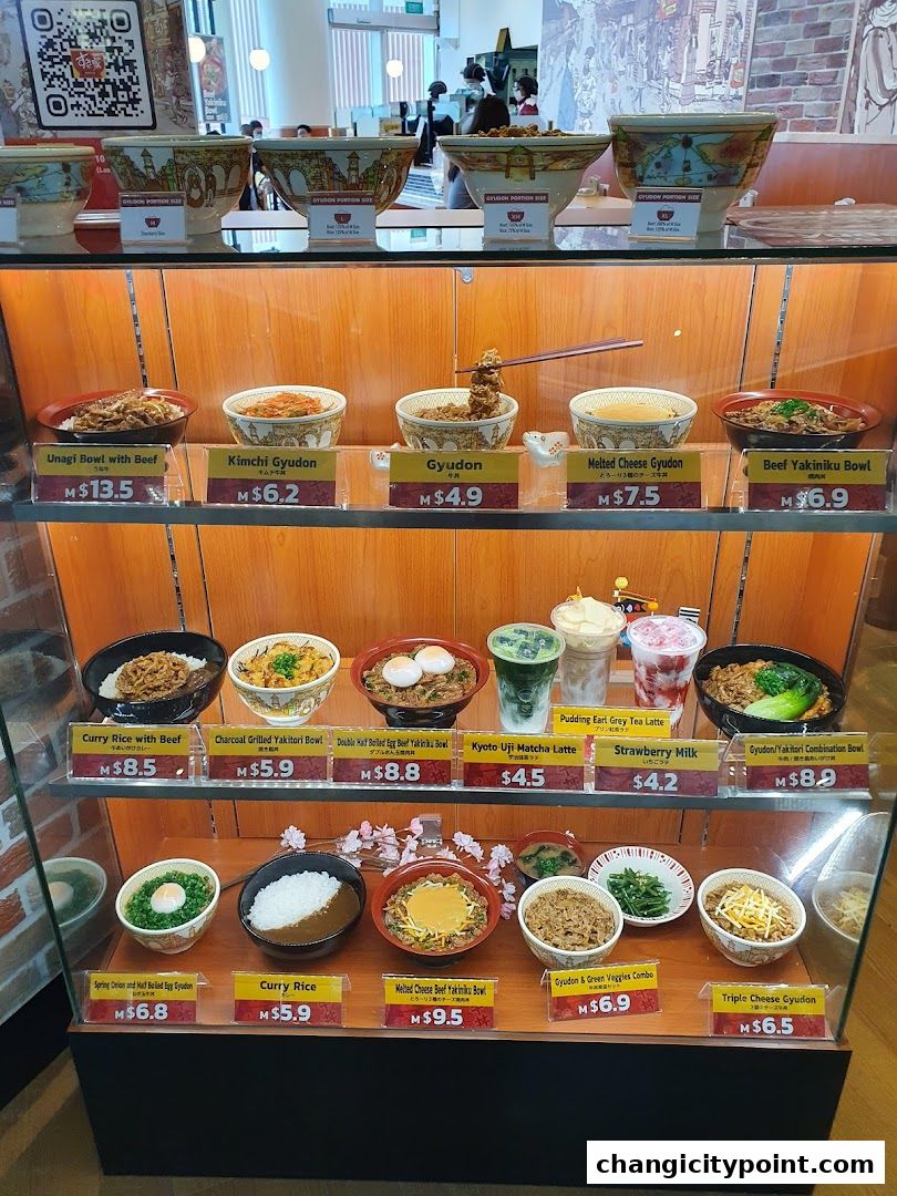 Display case showcasing various Japanese rice bowls and drinks with prices.