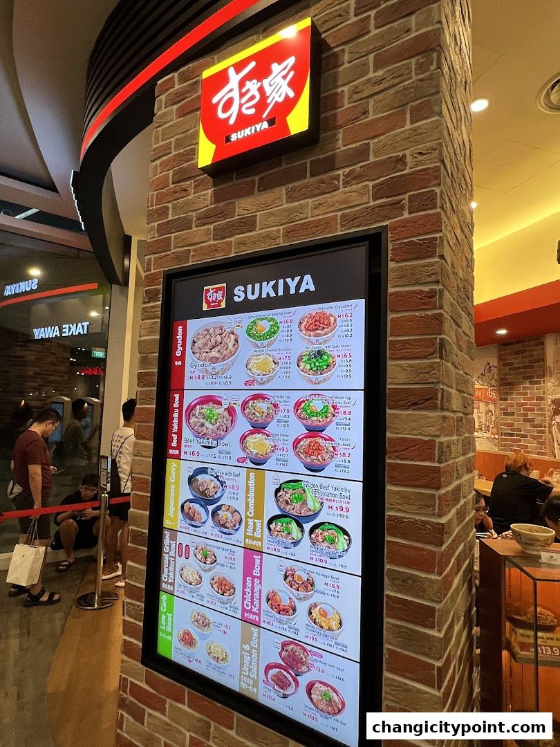 A digital menu board displays various Japanese rice bowl dishes from Sukiya.