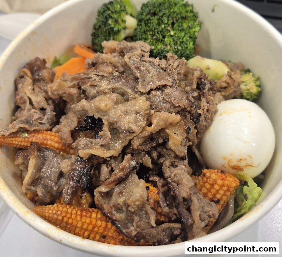 A bowl of beef, broccoli, corn, and egg with lettuce.