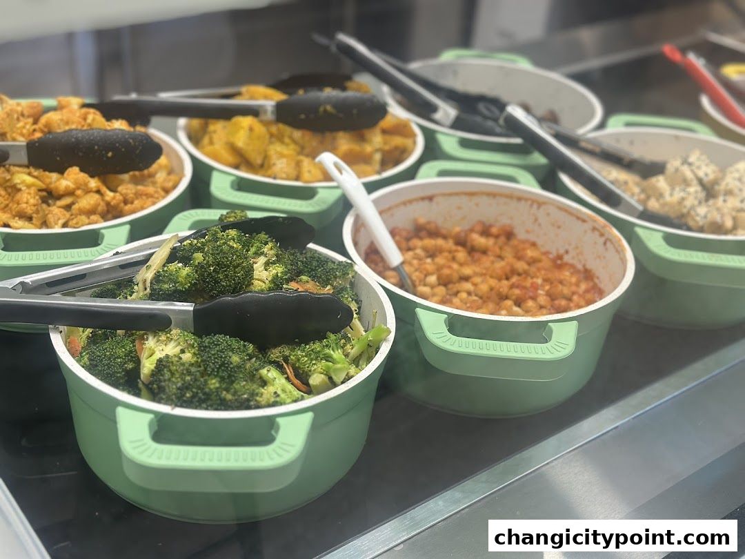 A selection of healthy and fresh dishes, including broccoli, chickpeas, and cauliflower, displayed in green bowls.