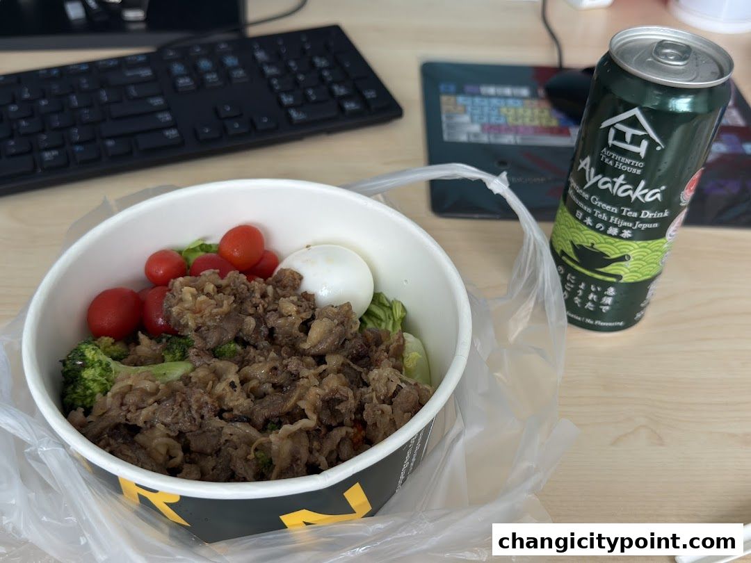 A bowl of beef and vegetable rice with a can of Ayataka green tea.