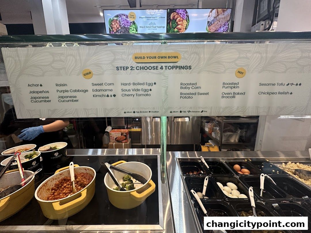 A menu board displays 'Build Your Own Bowl' with options for cold and hot toppings.
