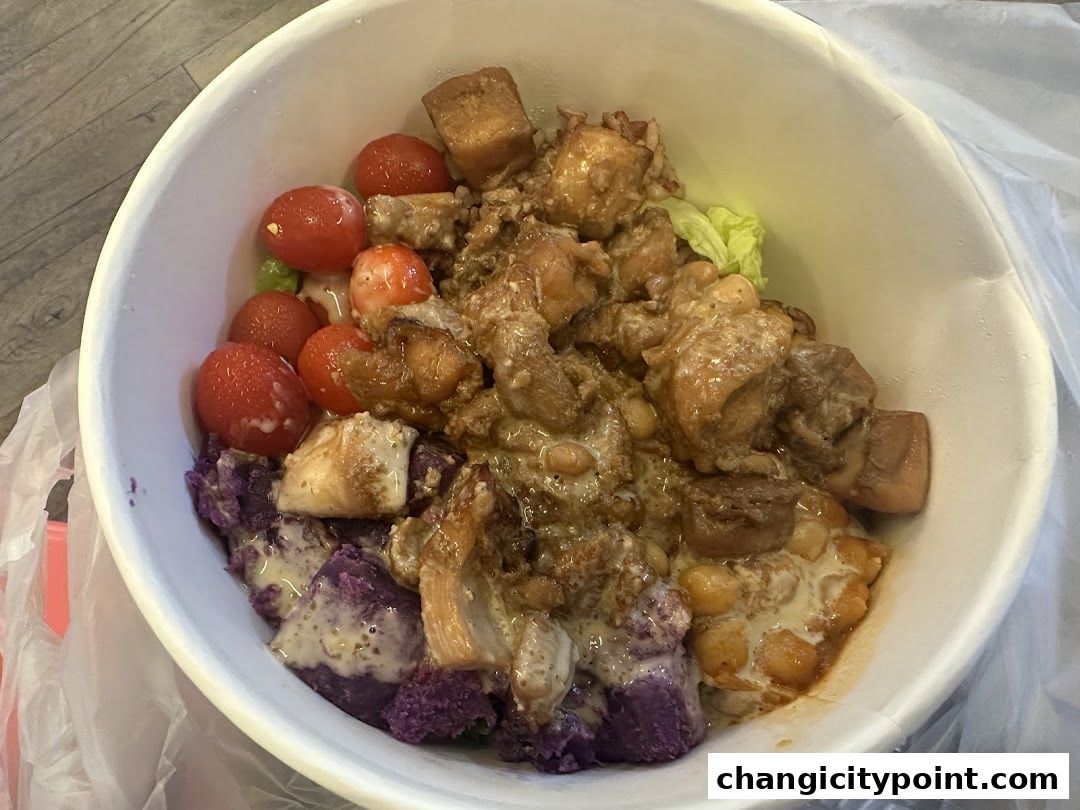 A white bowl filled with a colorful and hearty meal, featuring chicken, vegetables, and rice.