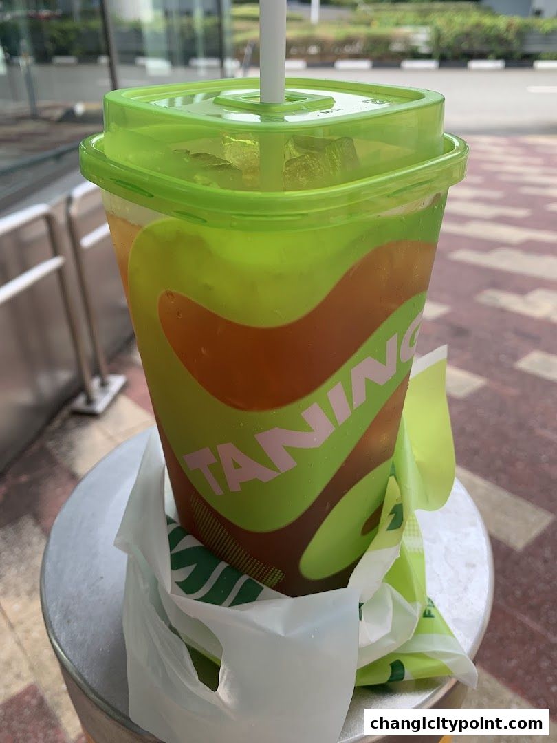 A refreshing iced tea from Taning, served in a branded cup with a green lid.