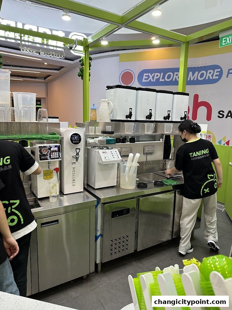 Staff preparing drinks at a beverage counter with dispensers and equipment.
