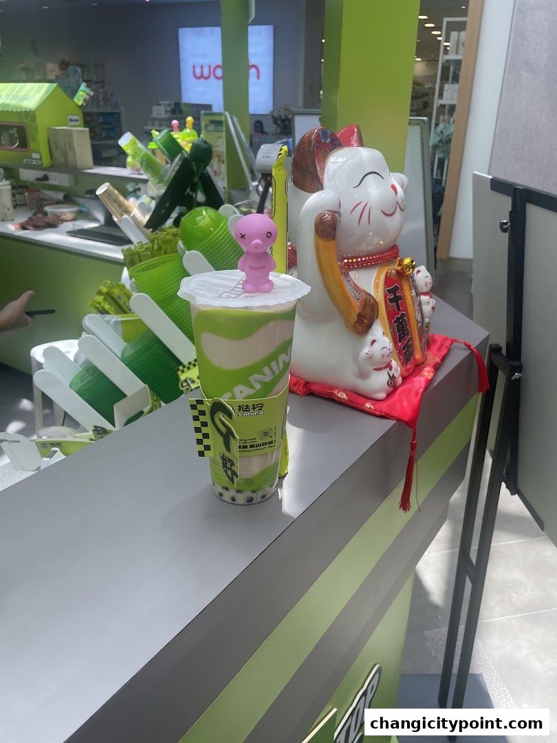 A bubble tea drink with a small pink octopus toy on top sits on a counter.