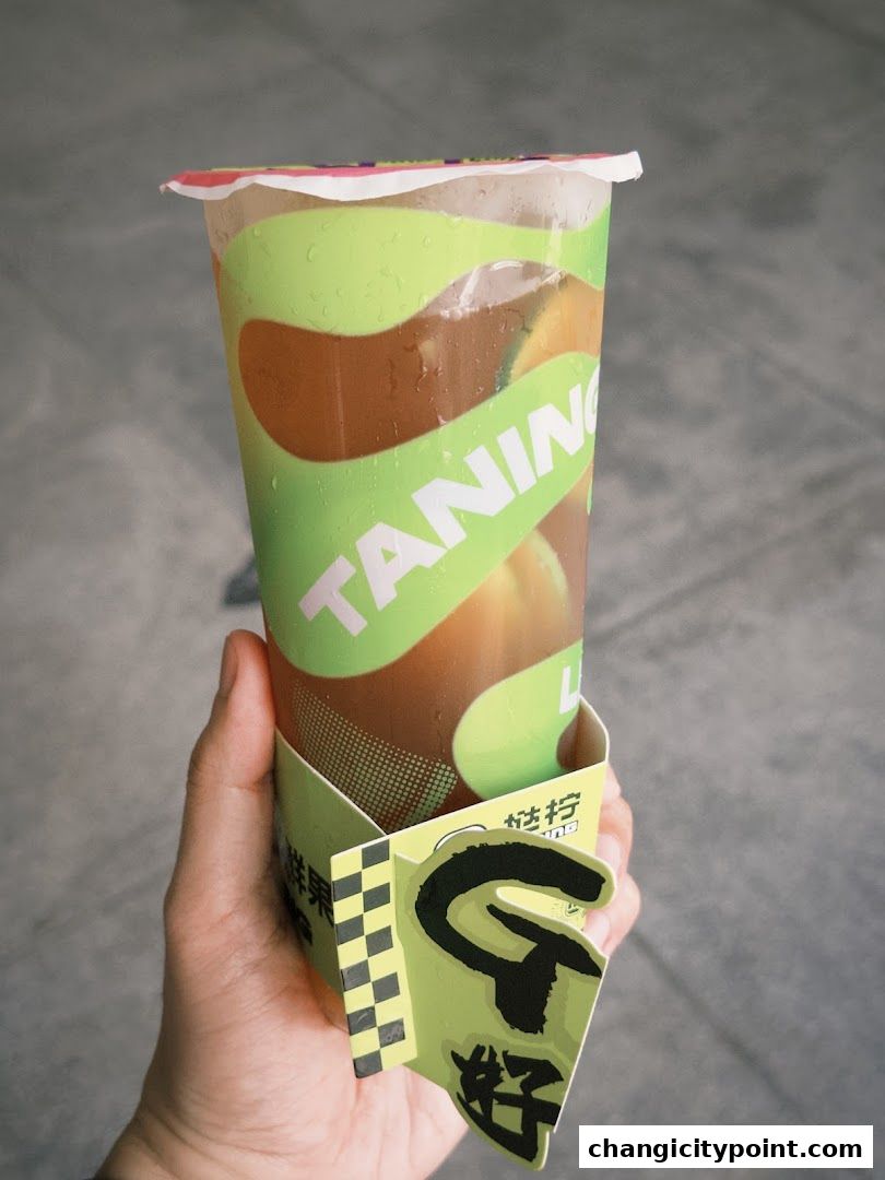A hand holds a refreshing beverage from Taning Changi City Point.
