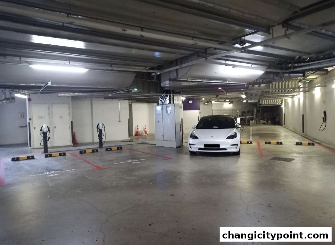 A white Tesla parked at a Tesla Destination Charger station in a parking garage.
