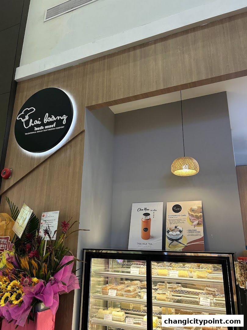 Thai Baang Bakery Changi City Point storefront with a display of baked goods and promotional posters.