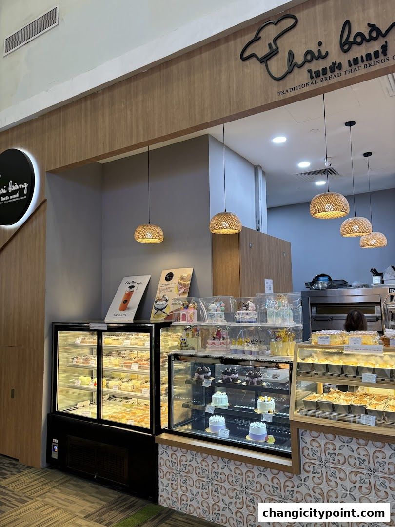Interior view of Thai Baang Bakery Changi City Point showcasing display cases filled with bread and cakes.