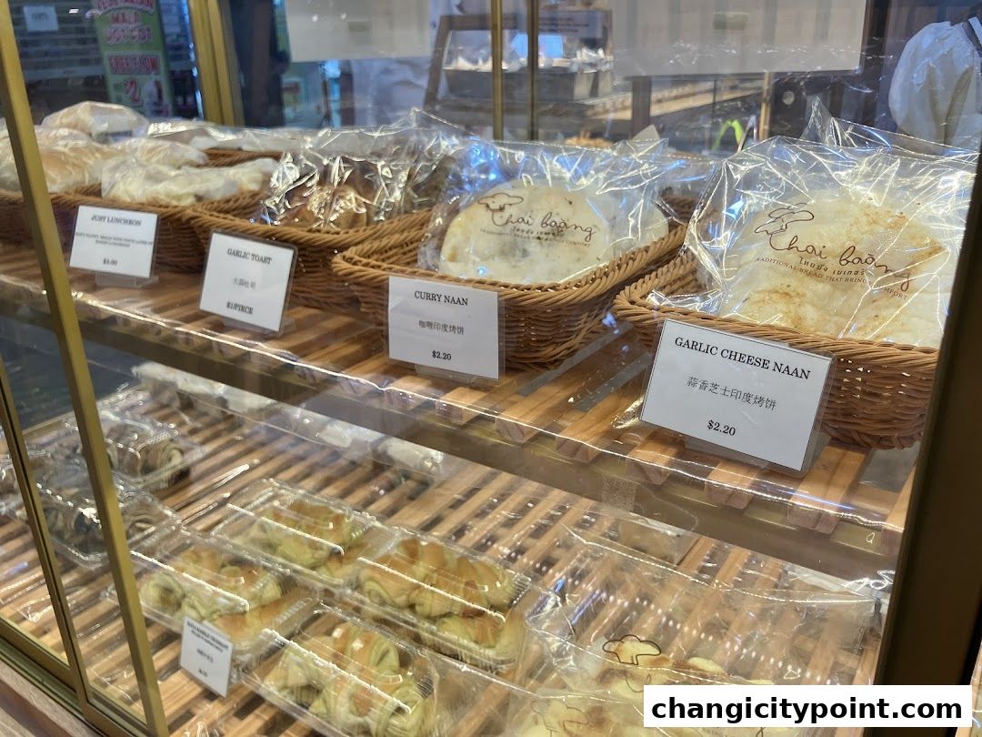 A display case filled with various baked goods, including naan and pastries, from Thai Baang Bakery.