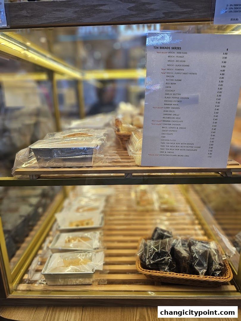 A menu displaying a variety of tin breads and their prices at Thai Baang Bakery.