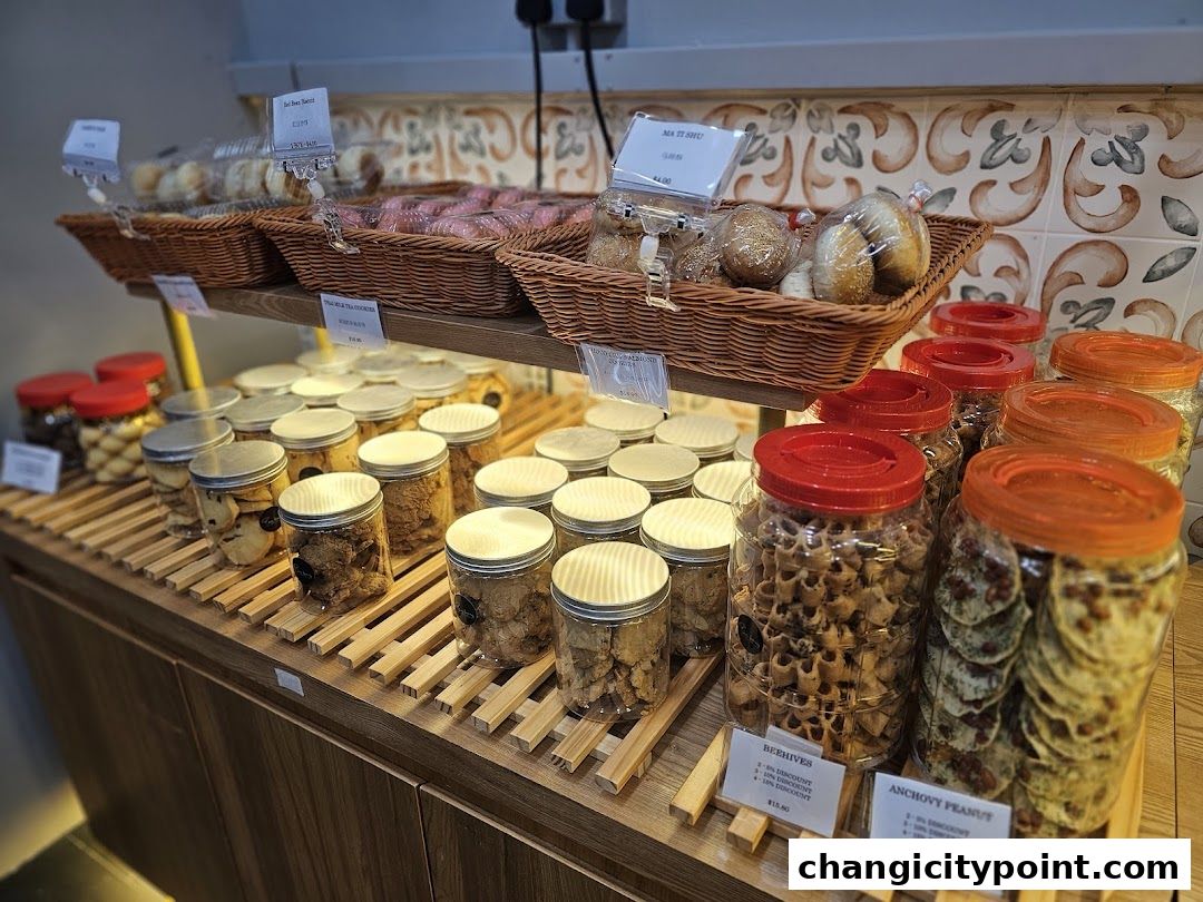A display of various baked goods and cookies in jars and baskets at a bakery.