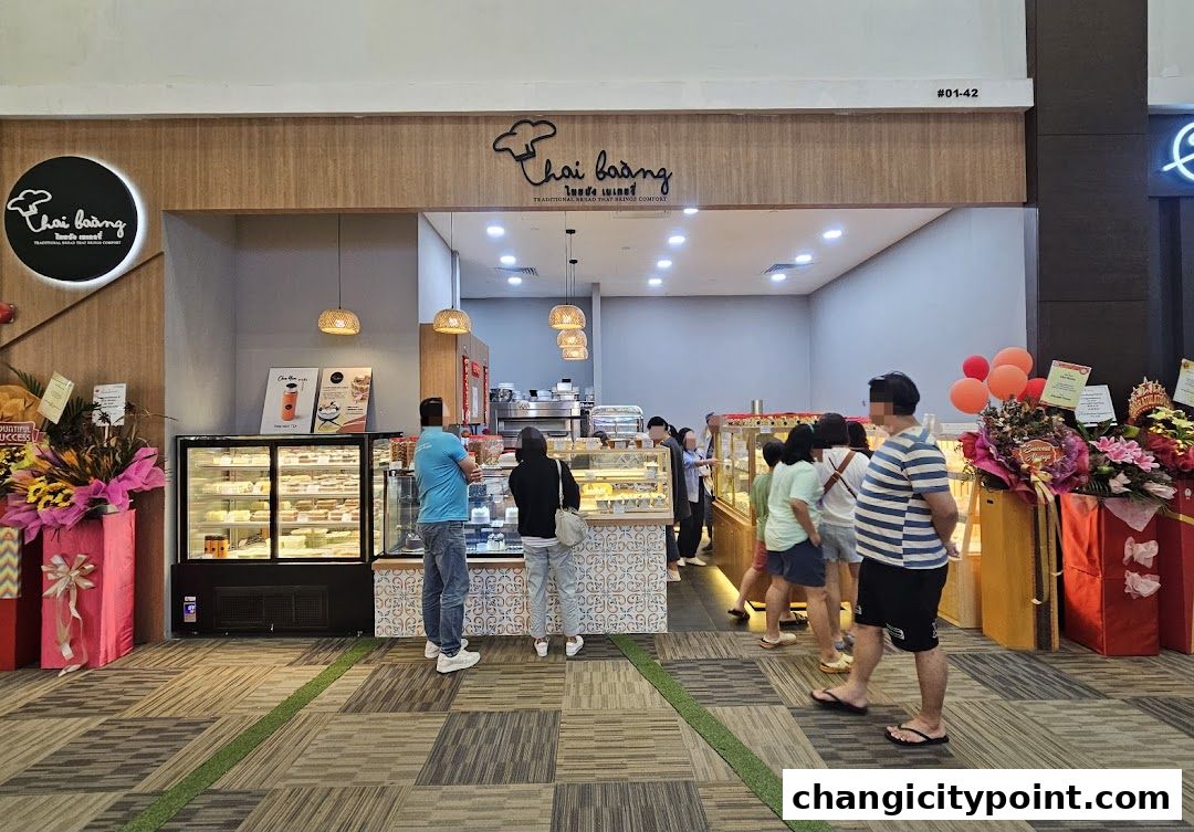 Thai Baang Bakery shop front with display cases and customers queuing.