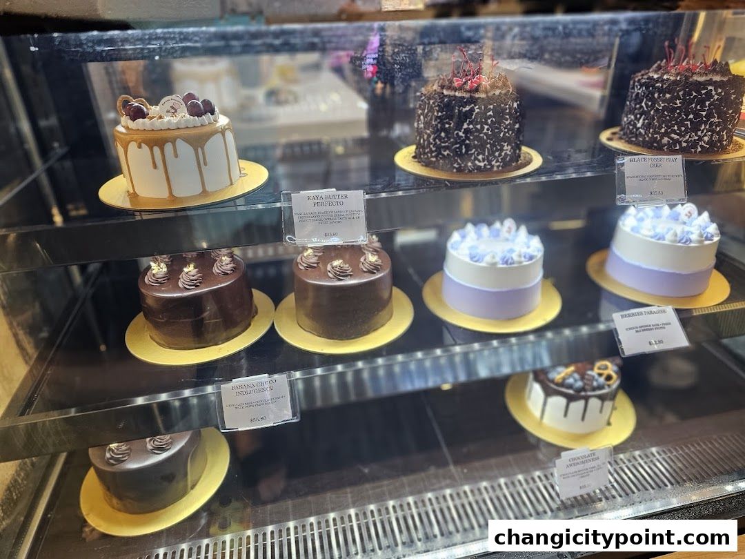 A display case filled with various beautifully decorated cakes, showcasing different flavors and designs.