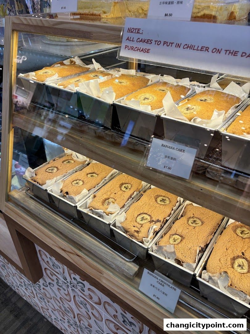 Display case filled with freshly baked banana cakes and banana chocolate cakes.