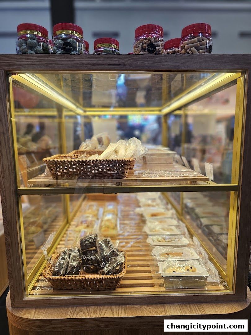 A display case filled with various baked goods, including cookies, brownies, and pastries.