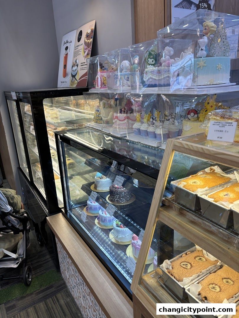 A display of beautifully decorated cakes and pastries in a bakery's refrigerated display case.