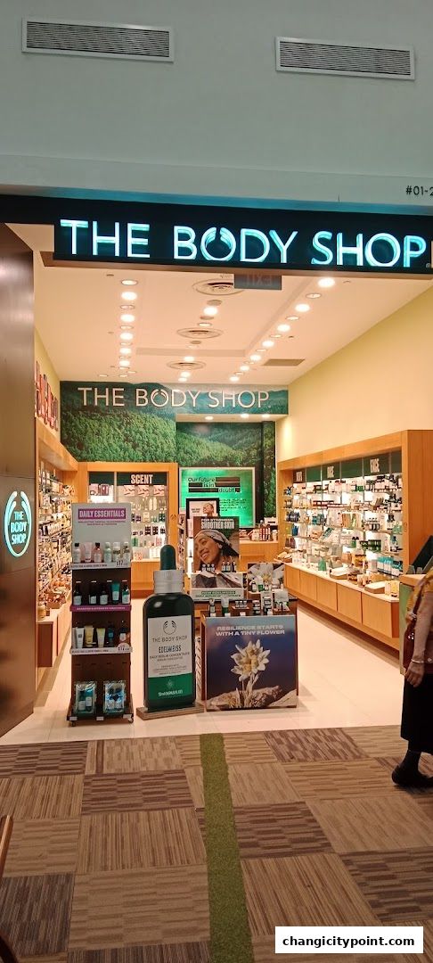 The Body Shop storefront displaying various skincare and beauty products, with a large Edelweiss serum bottle prominently featured.