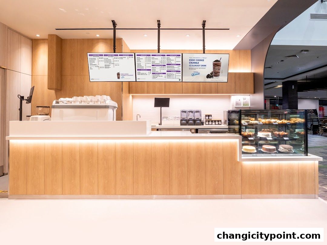 Interior view of The Coffee Bean Tea Leaf shop counter with pastries and digital menus.