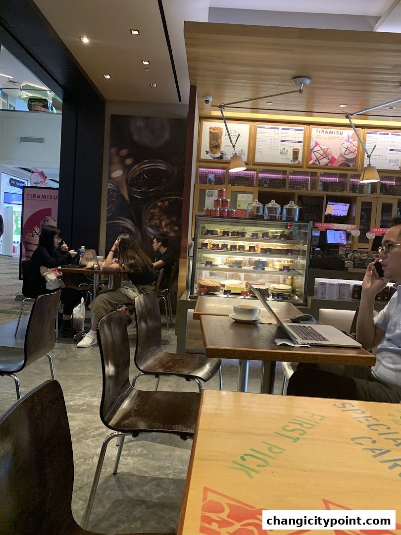 Interior view of The Coffee Bean Tea Leaf cafe with customers and display cases.