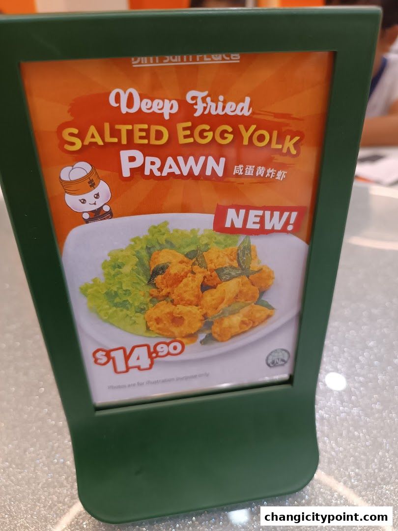 A sign advertising Deep Fried Salted Egg Yolk Prawns at The Dim Sum Place.