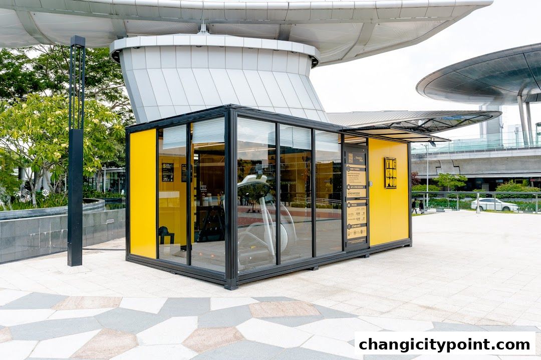 A modern, yellow and glass gym pod with exercise equipment visible inside.