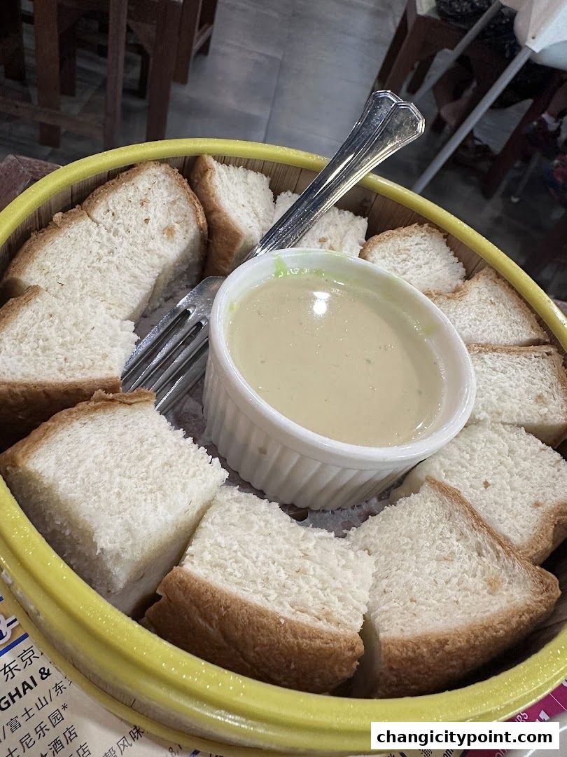 Steamed bread slices served with a creamy dipping sauce in a yellow bowl.