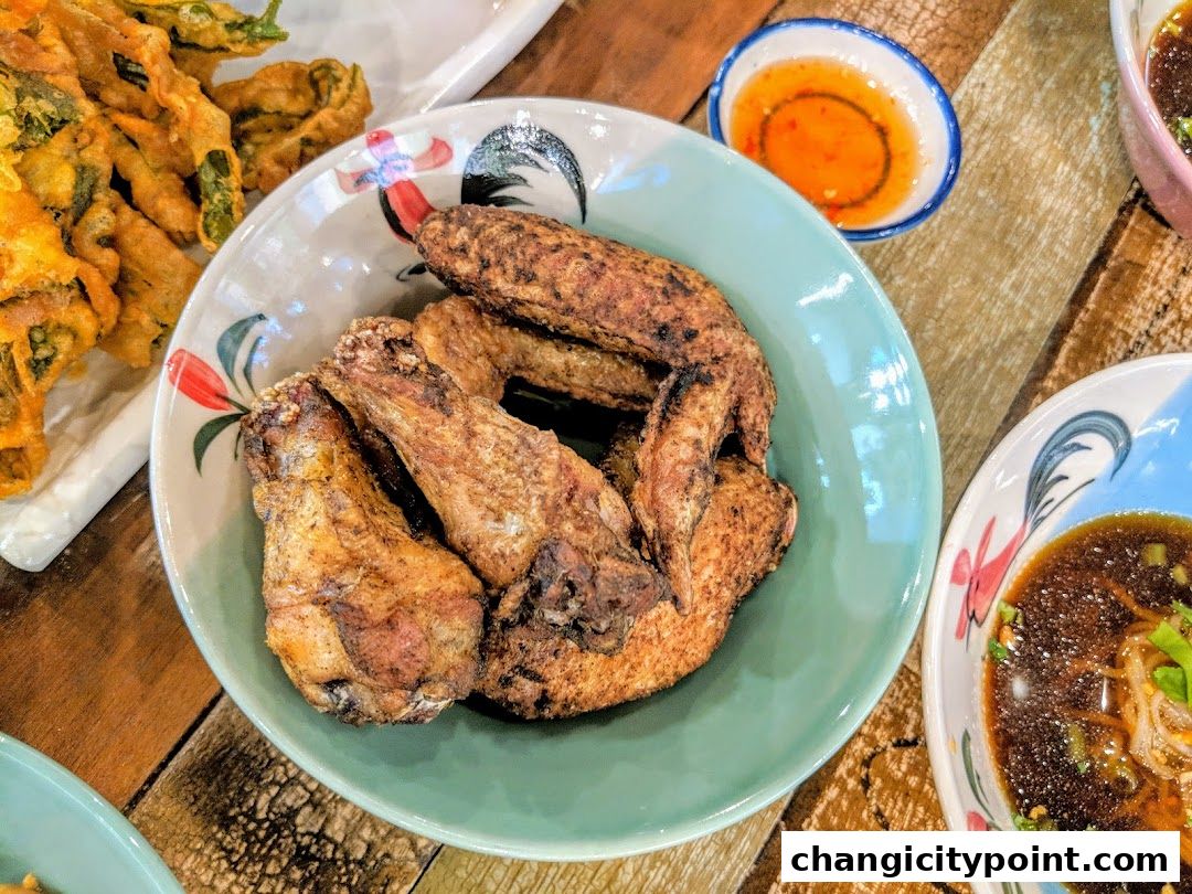 A close-up shot of delicious fried chicken wings served in a bowl with dipping sauce.