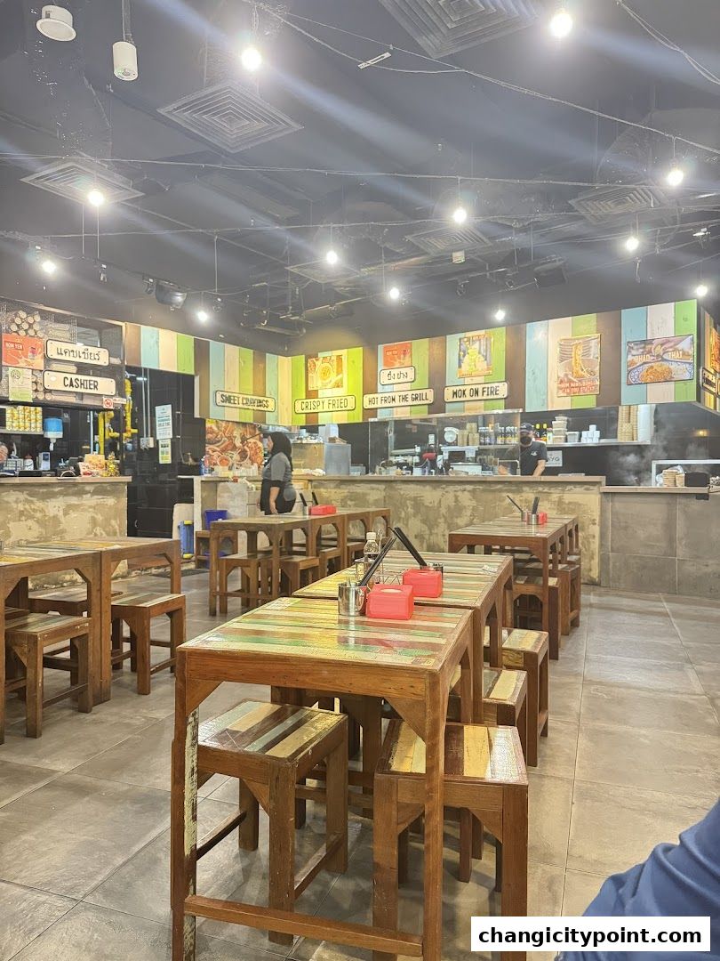 Interior of The Original Boat Noodle restaurant with wooden tables and chairs.