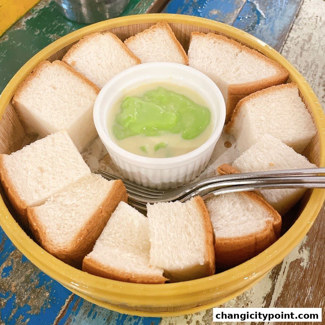 A bowl of sliced bread served with a creamy green dipping sauce.