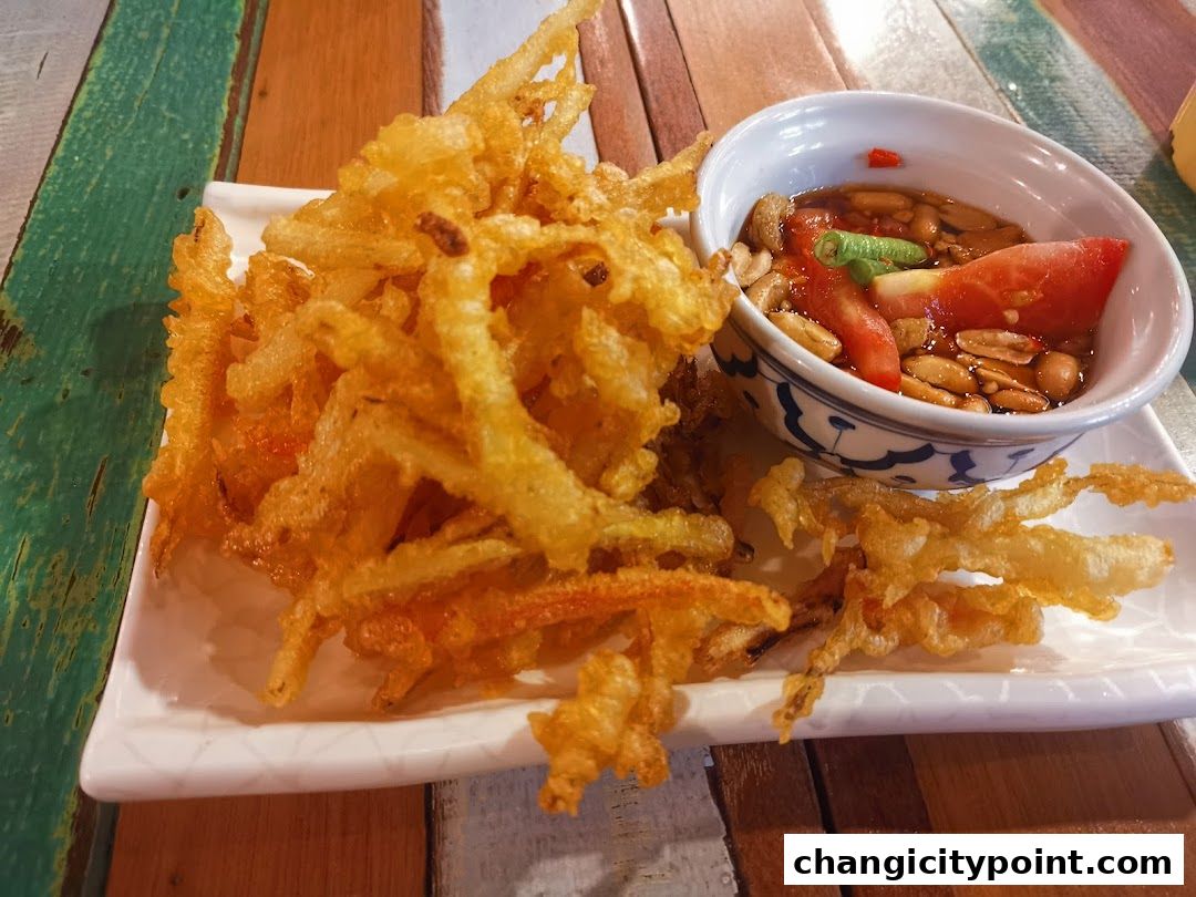 Crispy fried enoki mushrooms served with a spicy dipping sauce and peanuts.