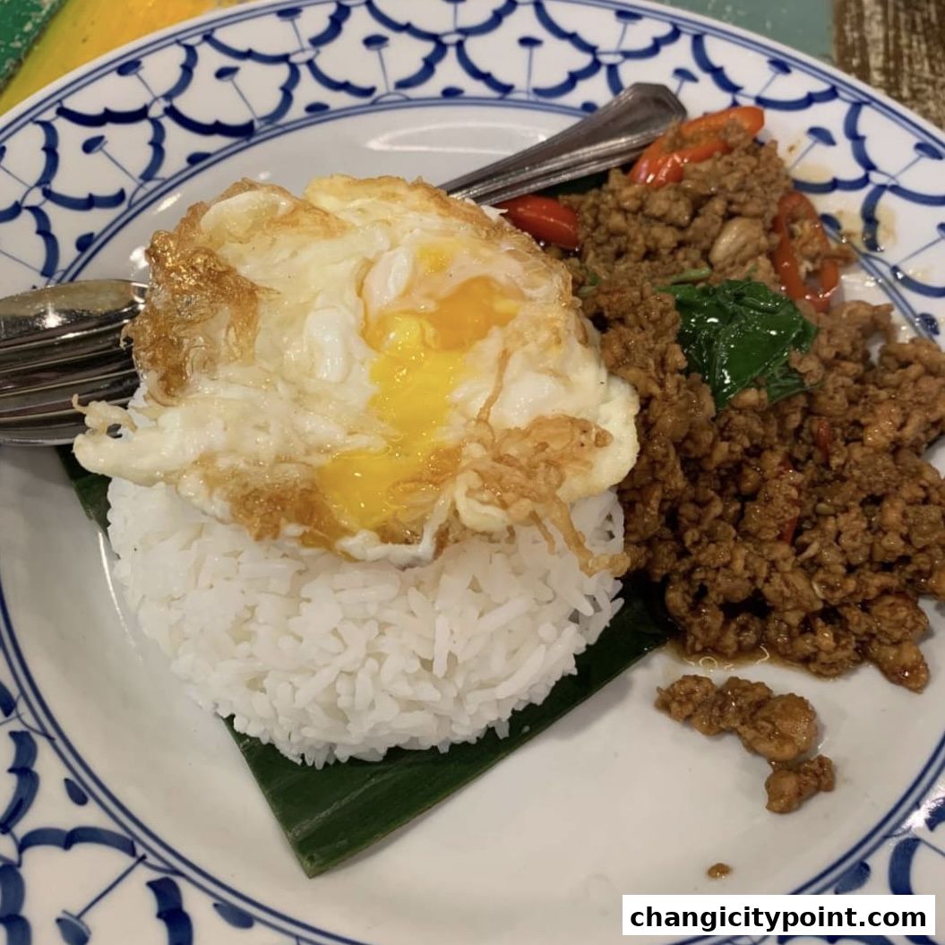 A plate of rice topped with a fried egg and minced meat stir-fry.