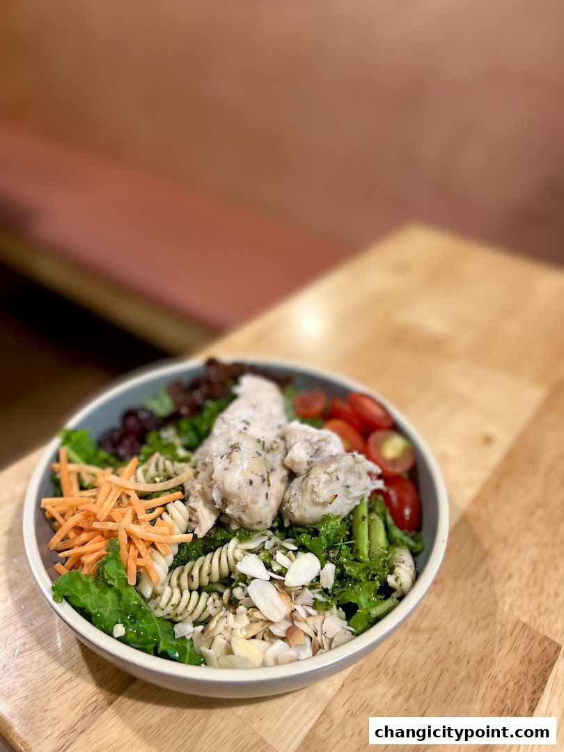 A delicious and healthy chicken pasta salad with fresh vegetables and almonds.