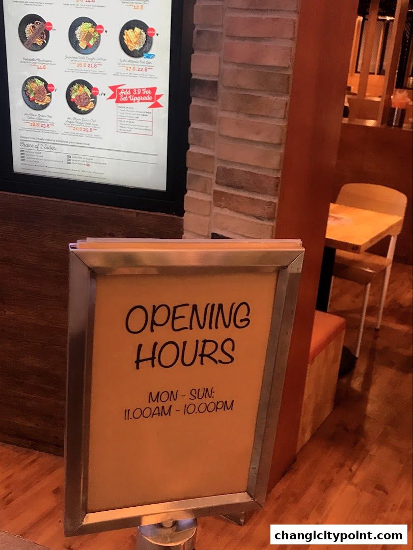 A menu board displays food items and prices, with an opening hours sign below.