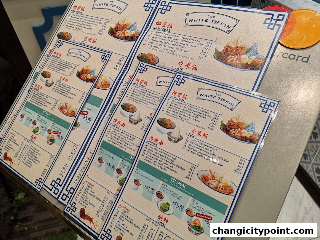 A close-up of several menus from The White Tiffin, showcasing food items and prices.