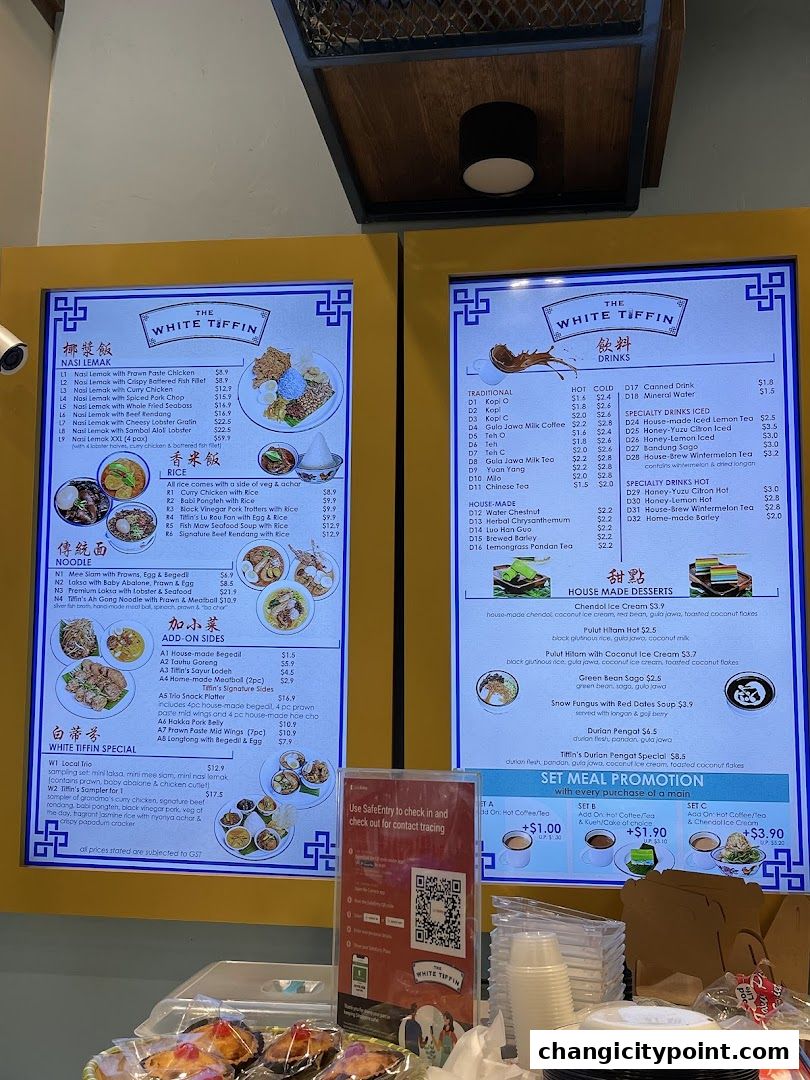 A digital menu board displaying various food and drink options from The White Tiffin.