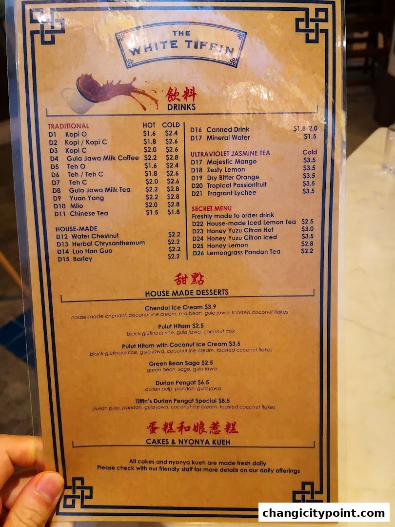 A menu from The White Tiffin featuring drinks, desserts, and cakes.