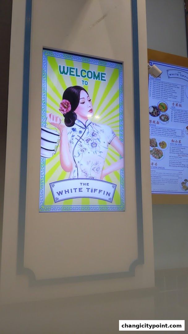 A digital display welcomes visitors to The White Tiffin with a stylized illustration.
