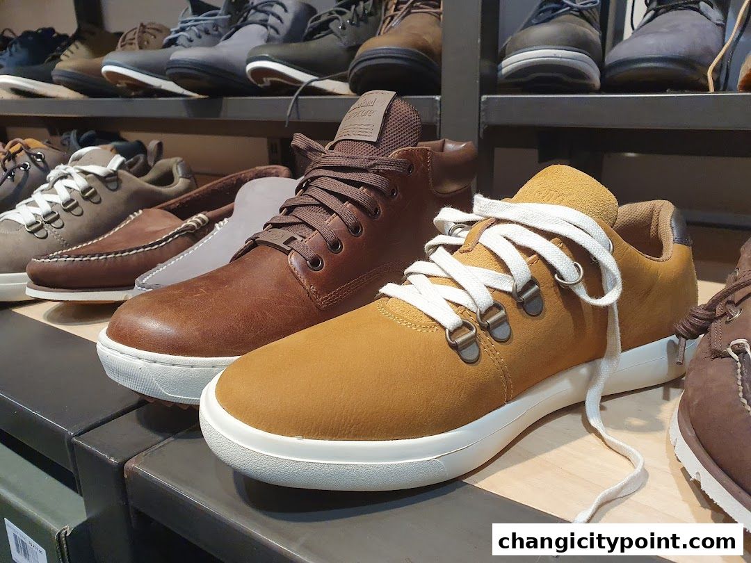 A display of various Timberland shoes, including boots and sneakers, on shelves.